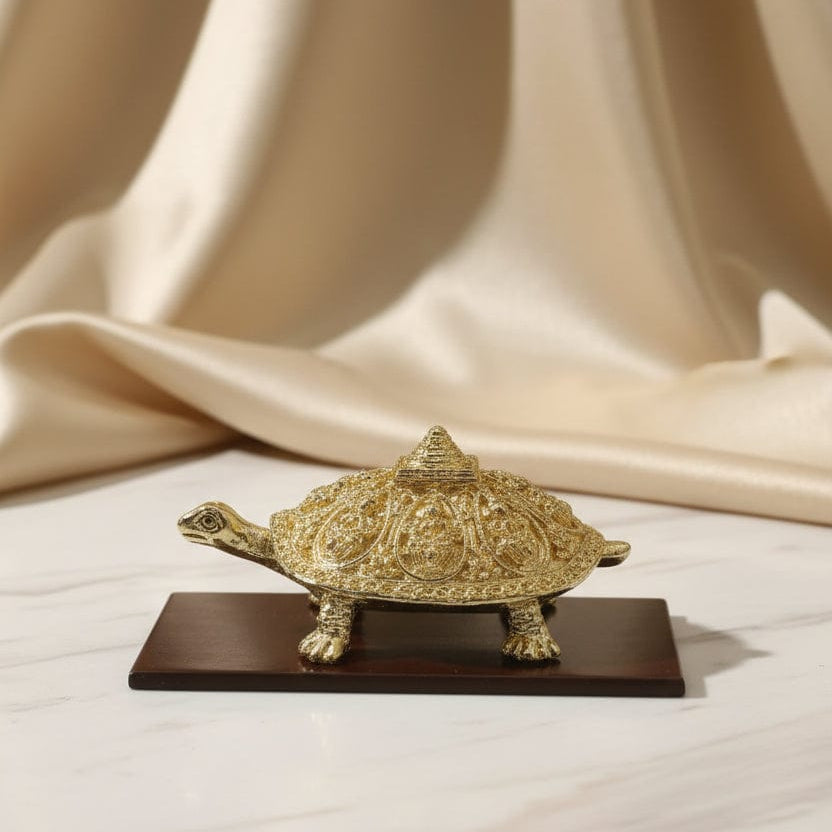 Gold decorative item on a wooden stand with a beige curtain background