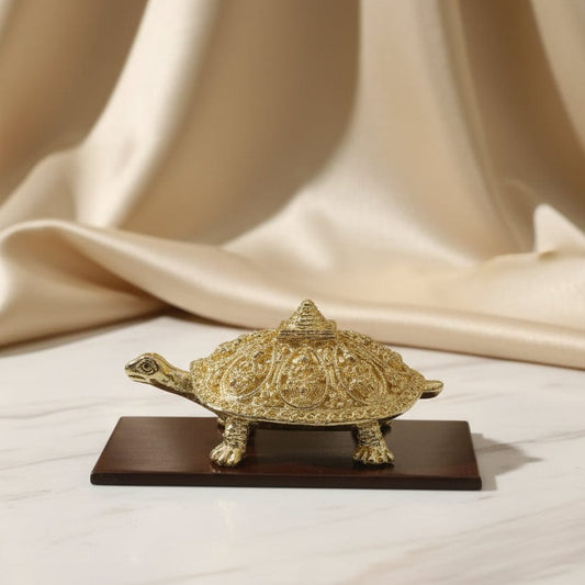 Gold decorative item on a wooden stand with a beige curtain background