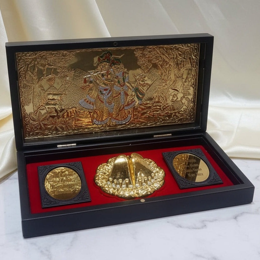Three gold coins in a decorative black and gold case on a white fabric background