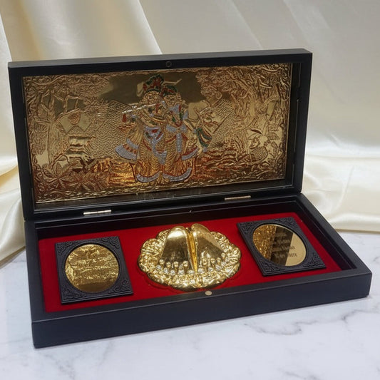 Three gold coins in a decorative black and gold case on a white fabric background