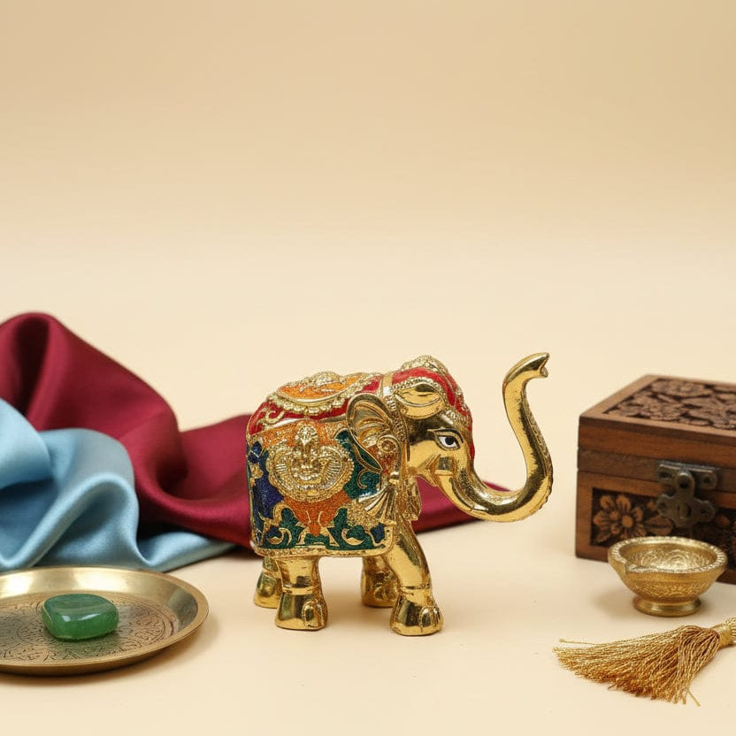 Decorative gold elephant figurine with colorful details on a beige background