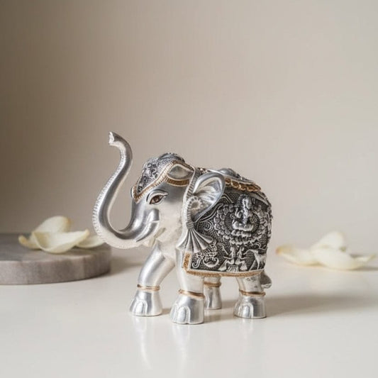 Decorative silver elephant figurines with intricate designs on a light background