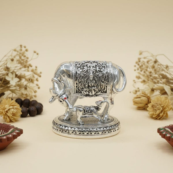 Decorative silver elephant figurine with small figures on a beige background, featuring the brand 'Kanuveda'.